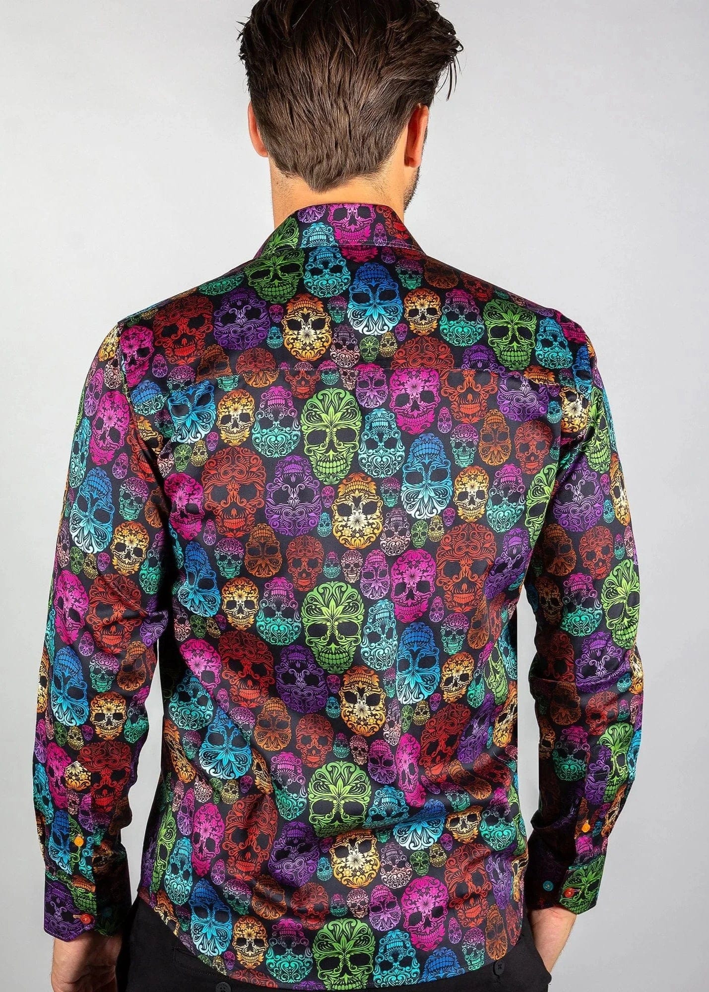 A man wearing a Claudio Lugli multicolored shirt with an ornamental skull pattern.