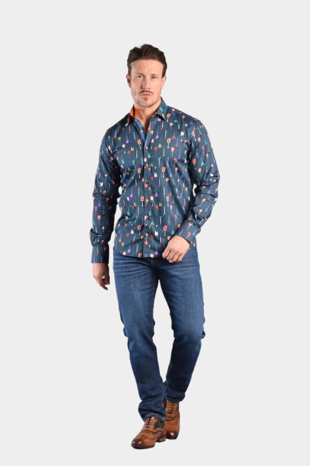 A man wearing a navy Claudio Lugli shirt with a guitars pattern, paired with blue jeans and brown leather shoes.