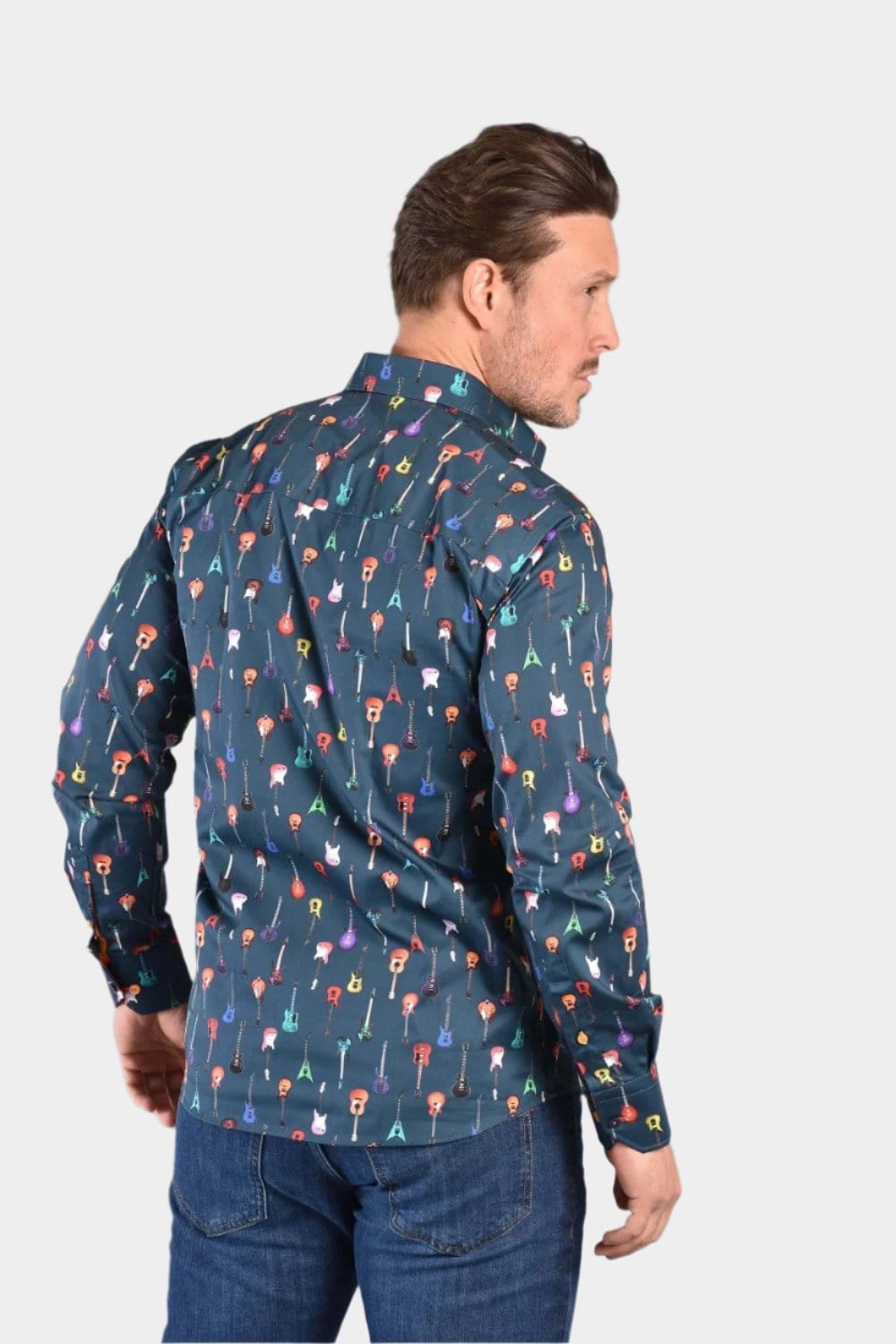 A man wearing a navy Claudio Lugli shirt with a guitars pattern, paired with blue jeans.