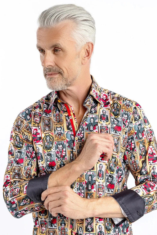 A man wearing a Claudio Lugli long-sleeve shirt with a bold joker-themed print in gold, red, and black, paired with dark trousers.