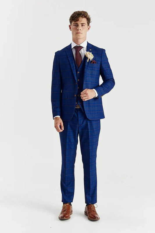 Man wearing a blue checkered suit with a white shirt and brown shoes on a light gray background