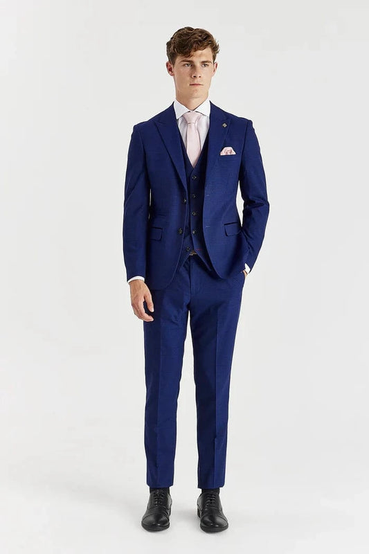 Man wearing a blue suit with a white shirt and black shoes on a white background