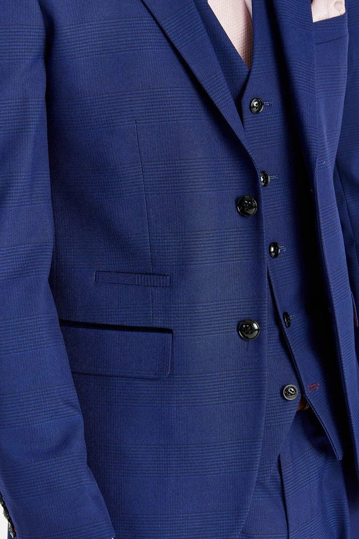 Close-up of a blue suit with buttons and a pocket on a plain background