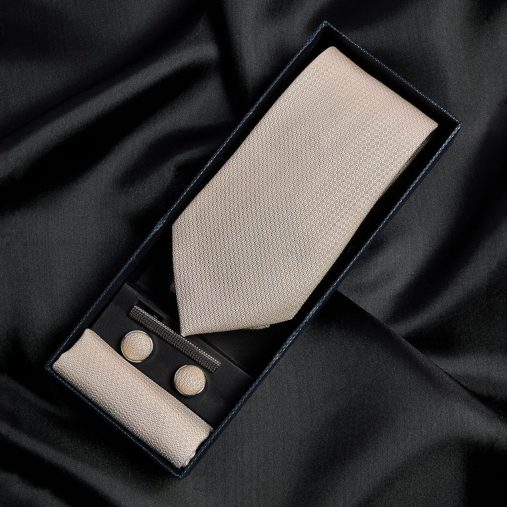 Paul Andrew champagne tie and cufflinks set in a black box on black fabric