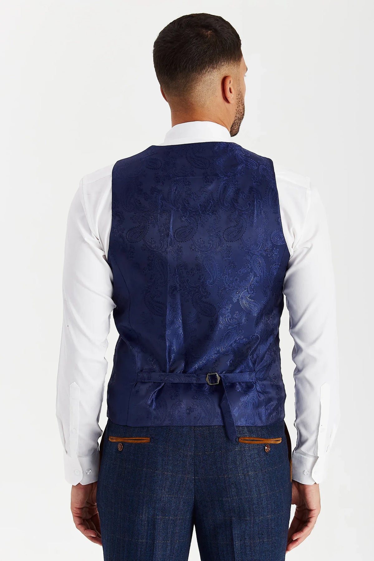 Rear view of the Paul Andrew Scott Navy Tweed Check men’s waistcoat from Menz Suits Stockport, showing adjustable back strap and blue paisley fabric.