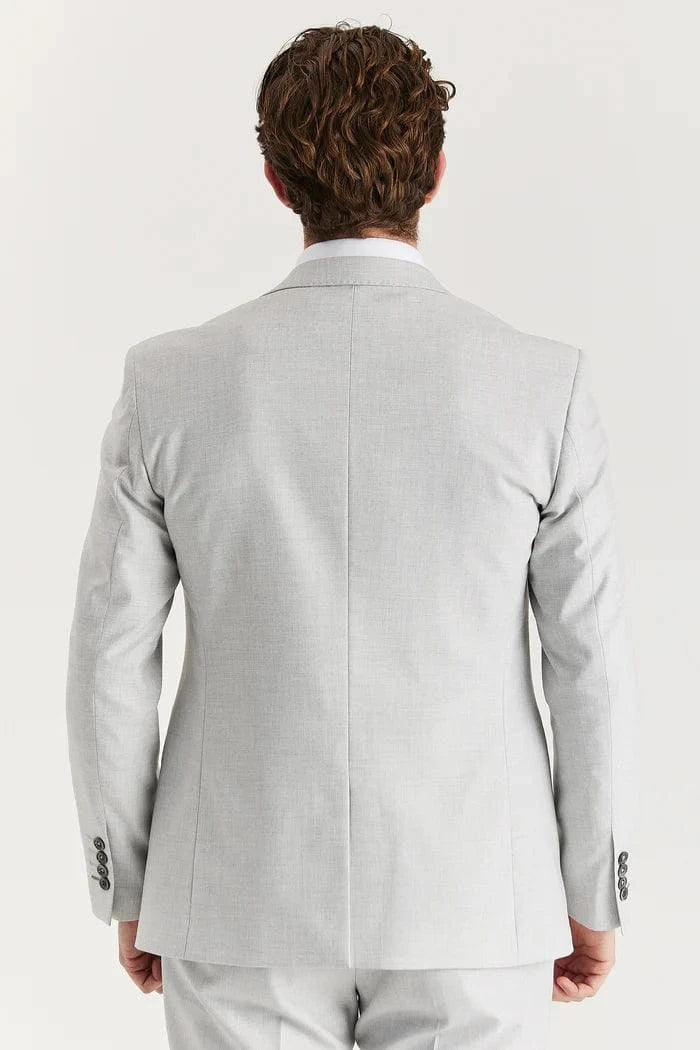 Rear view of a male model wearing the Paul Andrew Belmont Light Grey men’s suit from Menz Suits Stockport, highlighting double vents and smooth grey fabric.