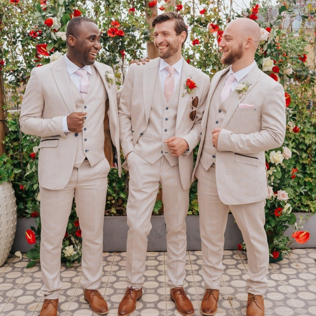 three men at a wedding. one groom and two groomen wearing caridi beige three piece suits at a wedding