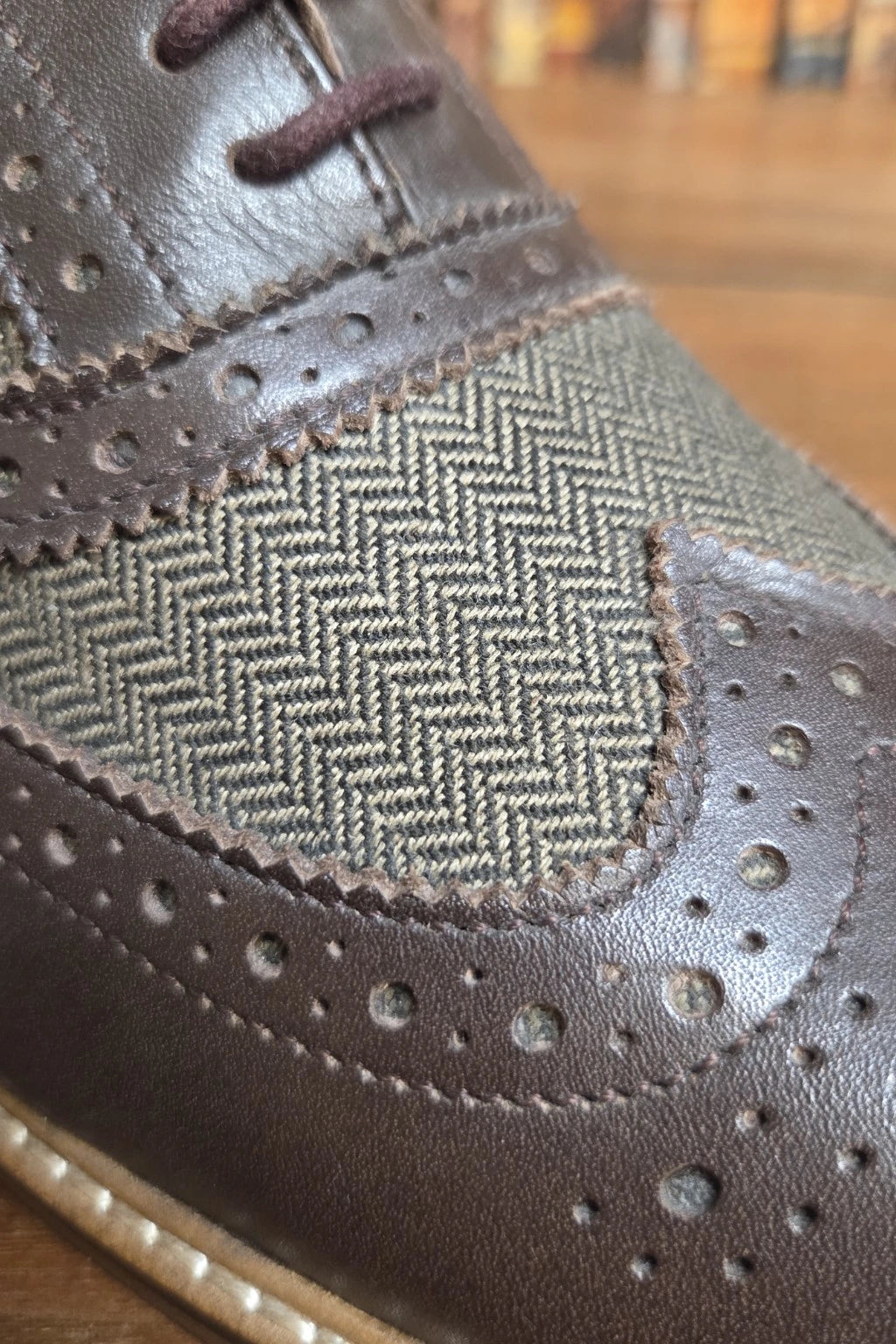 Close-up of a Cavani Ellington brown shoe with a herringbone-patterned fabric panel on the side, dark brown laces, and perforated brogue detailing.