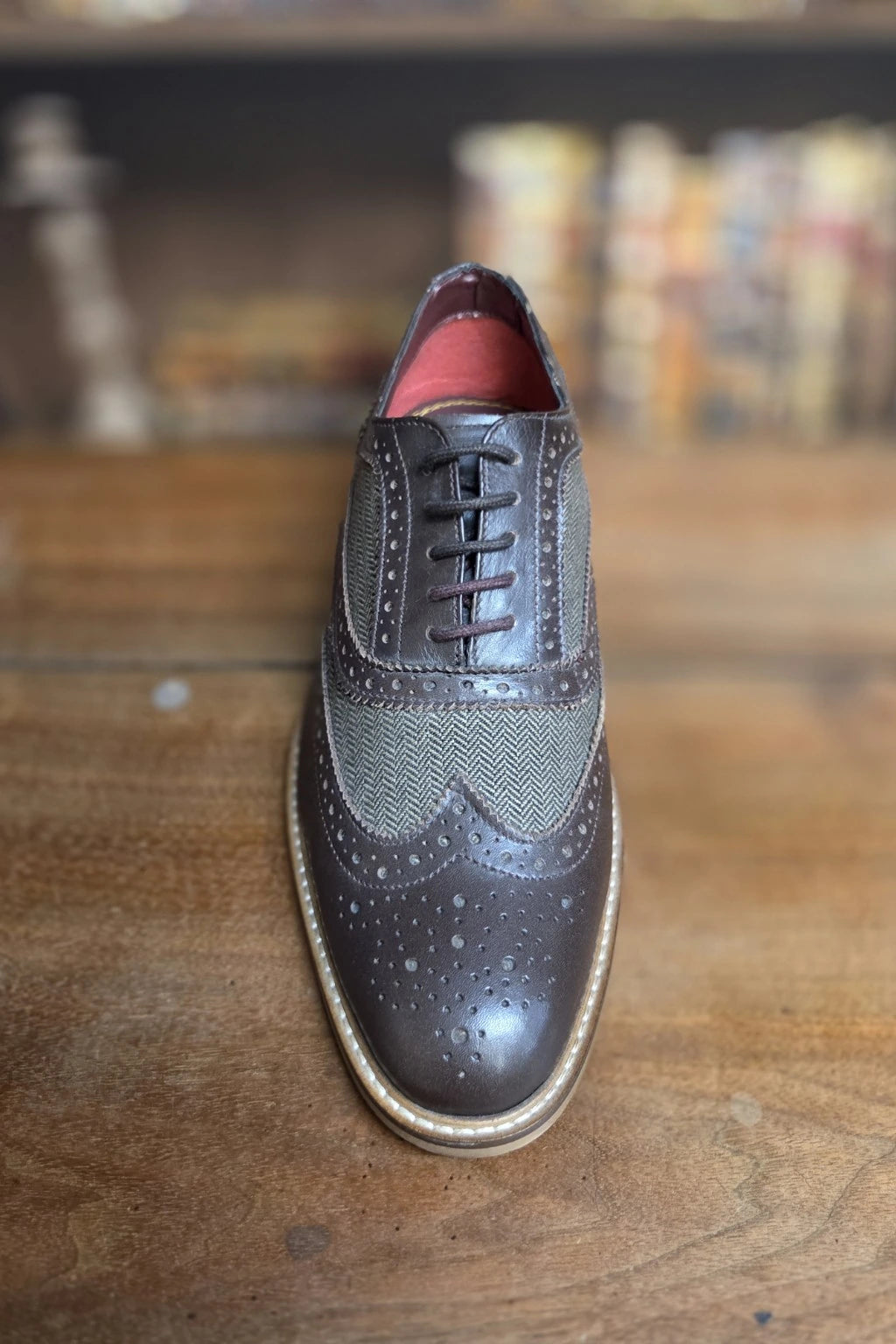 Men's Ellington brown shoes, shown from the front on a wooden surface with a blurred background.