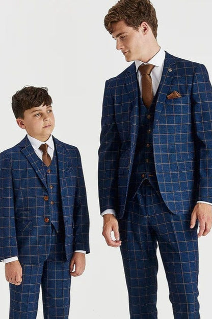 A father and son wearing matching Paul Andrew Hamleys blue checkered suits on a white background