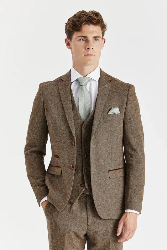 Man wearing a Paul Andrew Oscar brown tweed suit with a white shirt and brown shoes on a white background