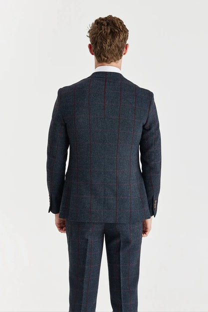 Man wearing a paul andrew navy check tweed suit with a white shirt a
 on a light gray background