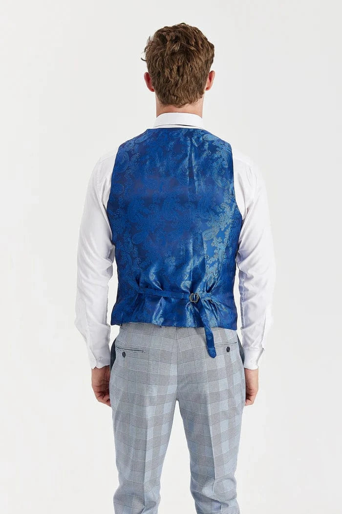 A person back wearing a waistcoat blue paisley design over a white shirt and sky blue checkered pants on a white background