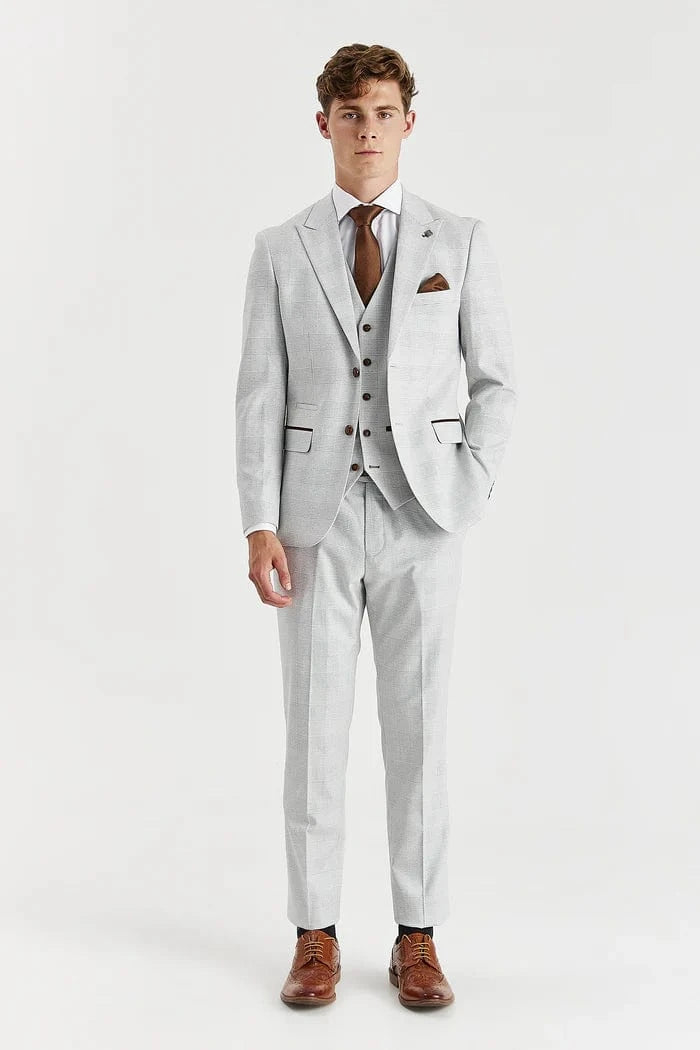 Man wearing a Paul Andrew stone check suit with a white shirt and brown shoes on a white background