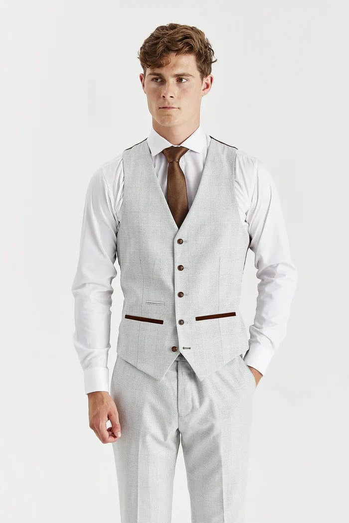 Man wearing a stone suit waistcoat with a white shirt and brown tie on a white background