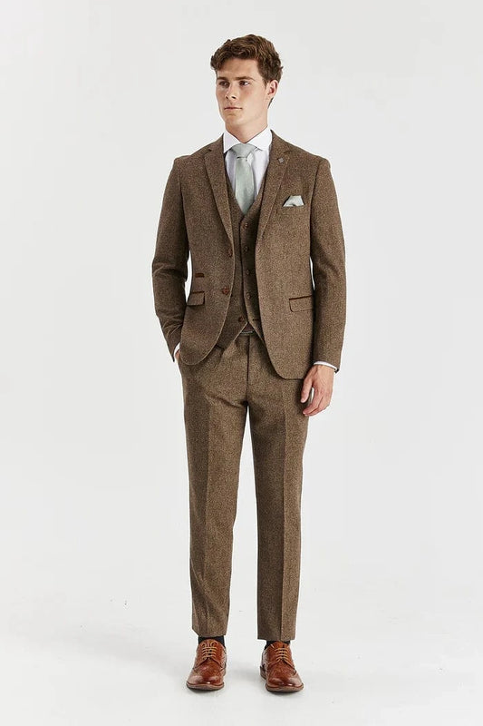 Man wearing a Paul Andrew Oscar brown tweed suit with a white shirt and brown shoes on a white background
