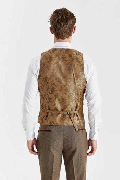 Man wearing a brown patterned vest over a white shirt and gray pants on a white background