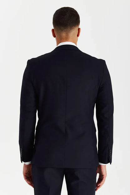 Rear view of a male model wearing the Paul Andrew Parker Navy Three Piece men’s suit from Menz Suits Stockport, highlighting double vents and modern fit.