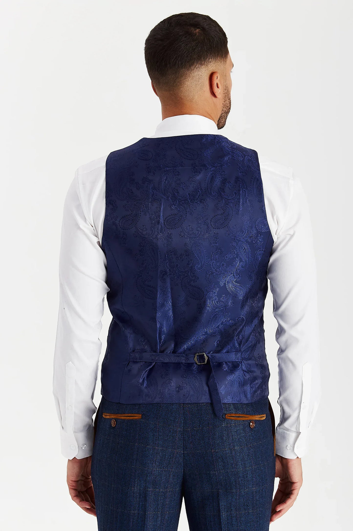 Rear view of the Paul Andrew Scott Navy Tweed Check men’s waistcoat from Menz Suits Stockport, showing adjustable back strap and blue paisley fabric.
