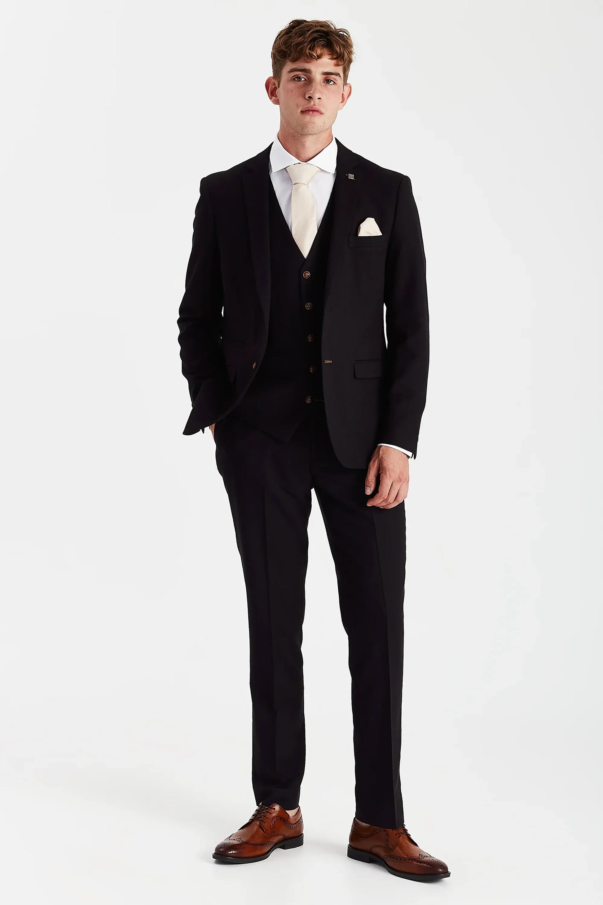 Male model wearing the Paul Andrew Mayfair Black Three Piece men’s wedding suit from Menz Suits Stockport, featuring black fabric and brown buttons.