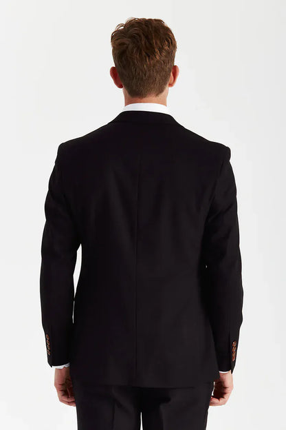 Rear view of a male model wearing the Paul Andrew Mayfair Black Three Piece men’s suit from Menz Suits Stockport, highlighting the back vents and black fabric.