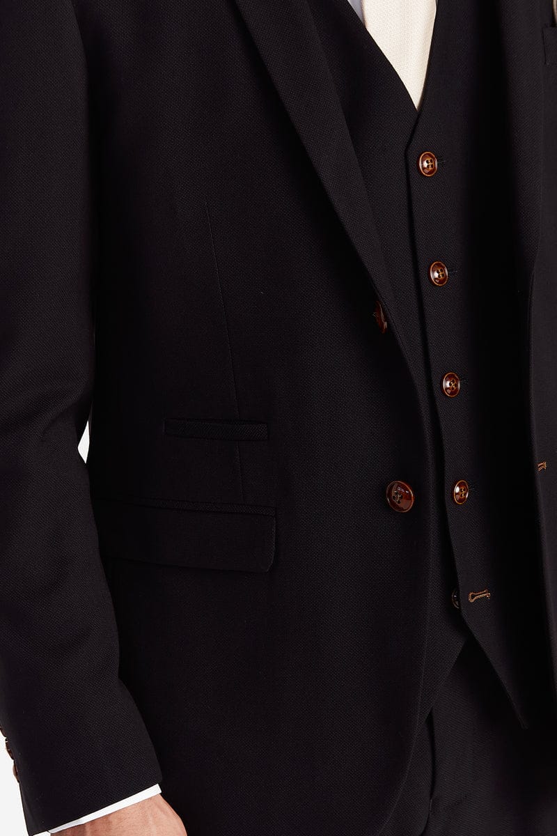 Close-up of the black suit jacket showing the brown buttons and textured fabric