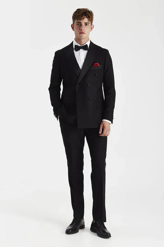 Male model wearing the Paul Andrew Harry Black Double Breasted Tuxedo Suit from Menz Suits Stockport, featuring satin peak lapel and tailored fit design.
