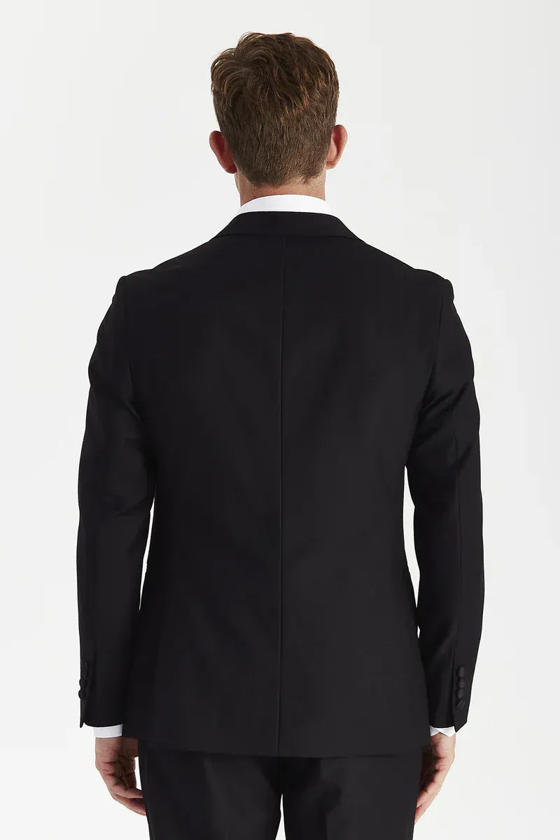 Rear view of a male model wearing the Paul Andrew Harry Black Double Breasted Tailored Fit Tuxedo Suit from Menz Suits Stockport, highlighting the structured silhouette and back vents.