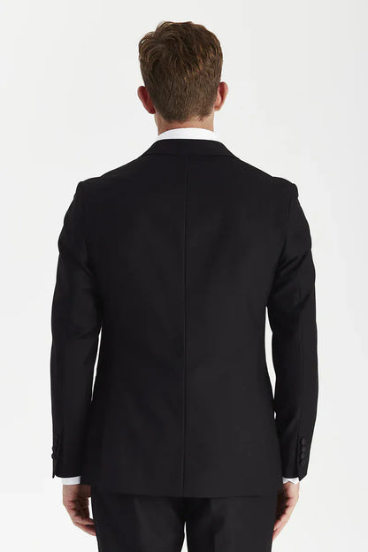 Rear view of a male model wearing the Paul Andrew Harry Black Double Breasted Tailored Fit Tuxedo Suit from Menz Suits Stockport, highlighting the structured silhouette and back vents.