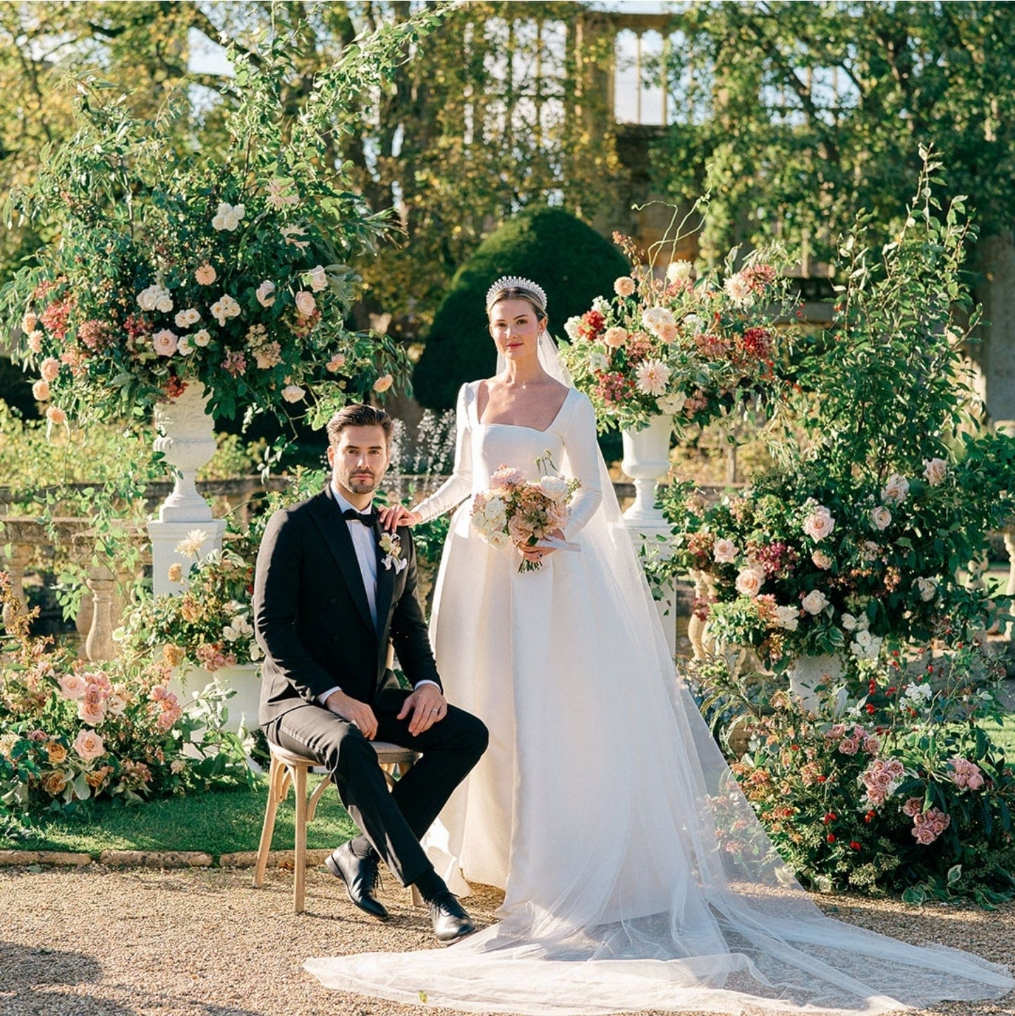 Wedding couple posing in a garden with floral decorations