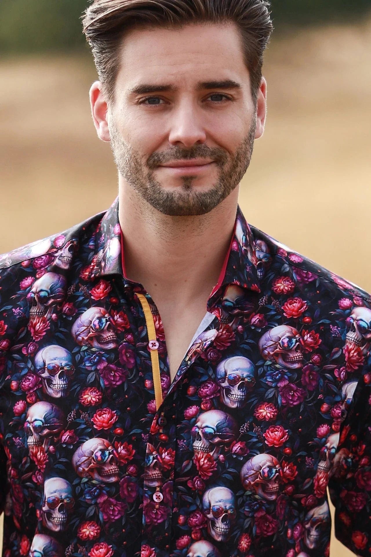 Man wearing a colorful Claudio Lugli shirt with skull and floral pattern.