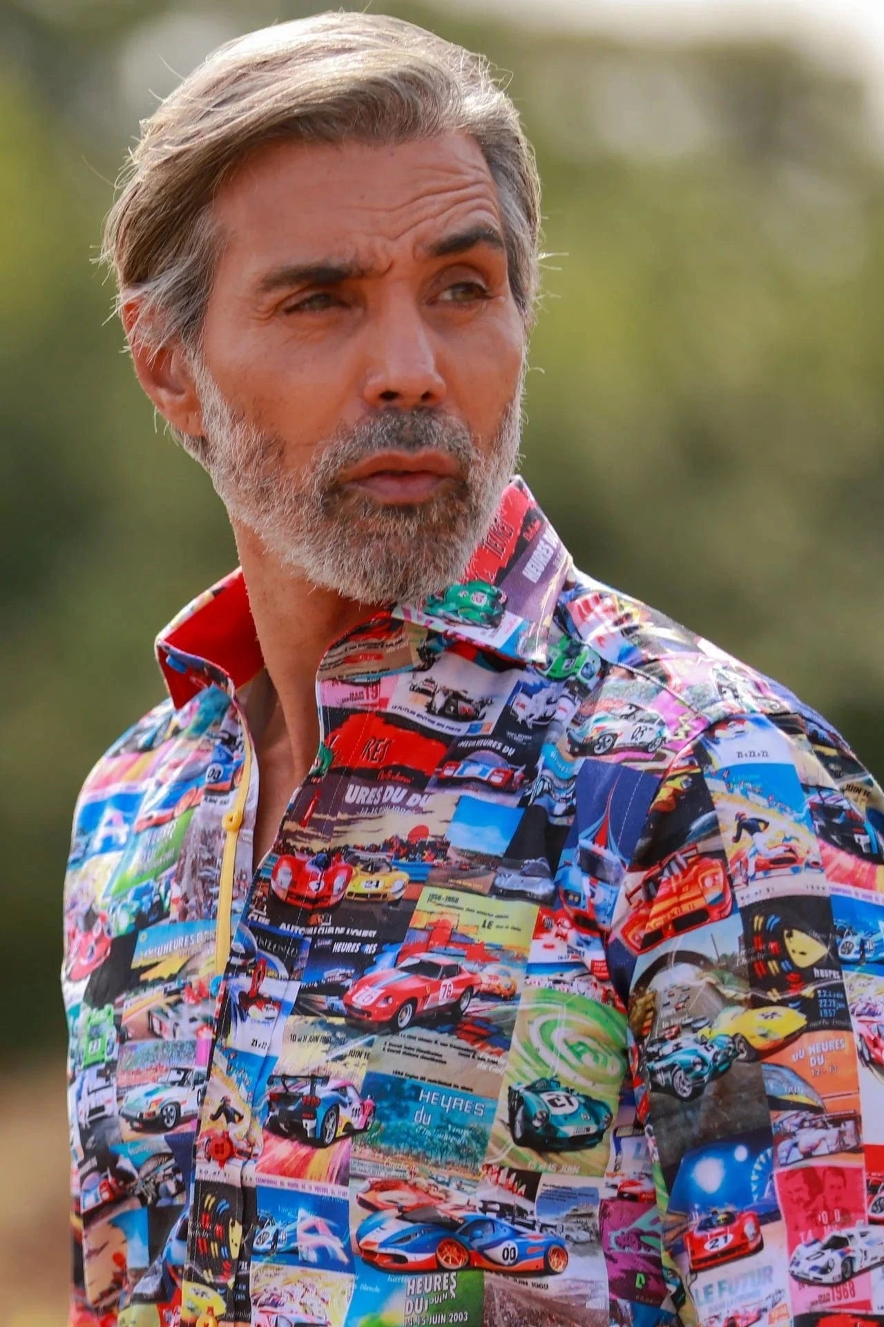Man wearing a colorful Claudio Lugli Le Mans shirt with car patterns outdoors