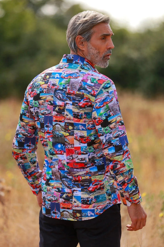 Man wearing a colorful Claudio Lugli Le Mans shirt with car patterns standing in a field.