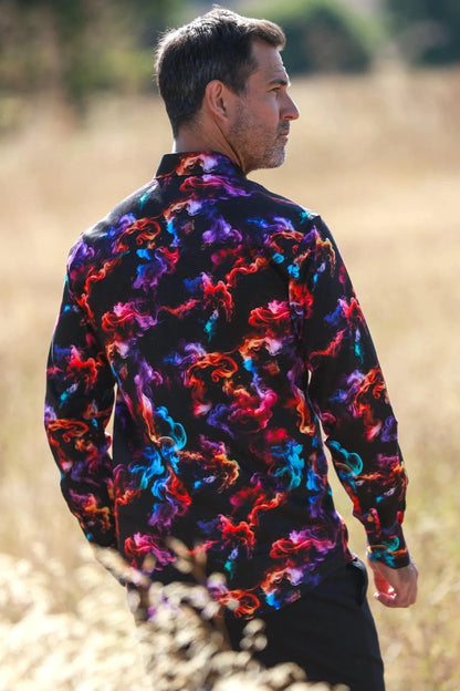 Man wearing a colorful Claudio Lugli patterned shirt standing in a field