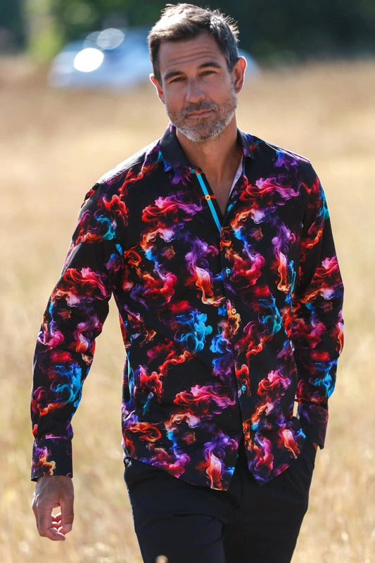 Man wearing a colorful Claudio Lugli patterned shirt walking outdoors.