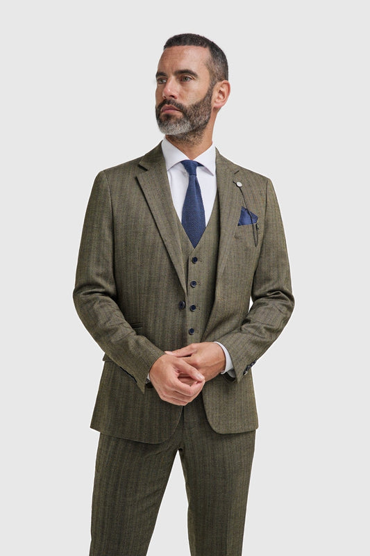 Man wearing a Cavani Damon sage tweed suit with a blue tie and pocket square on a white background