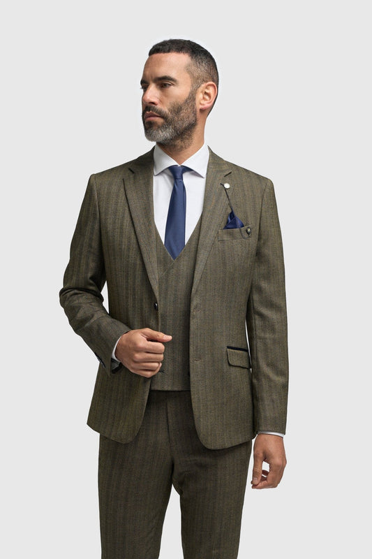 Man wearing a Cavani Damon Sage Tweed suit with a white shirt and blue tie on a white background